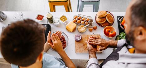 a couple of kids eating at a table with food on it